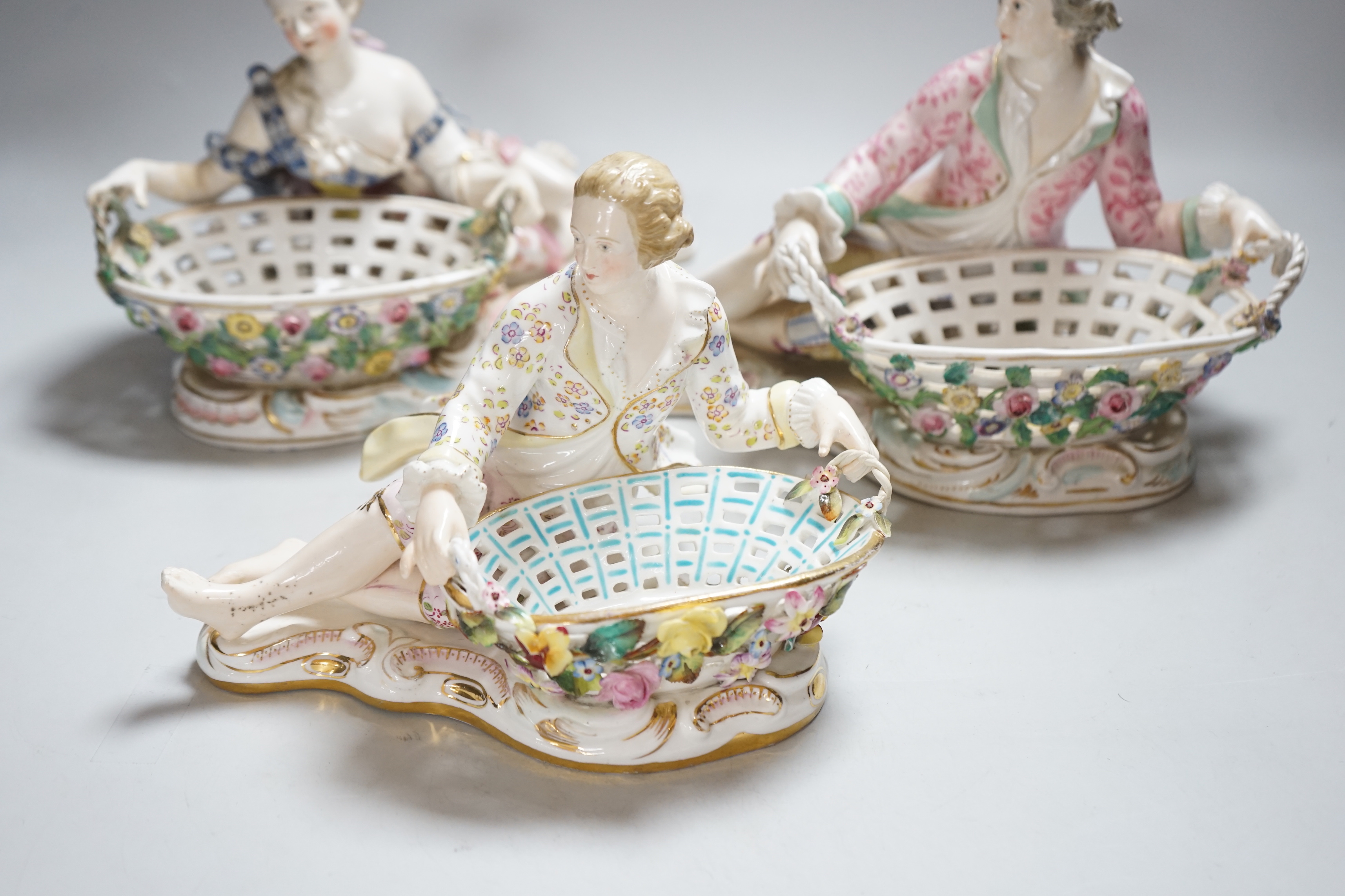 Three English porcelain Meissen style figural baskets, highest 18cm